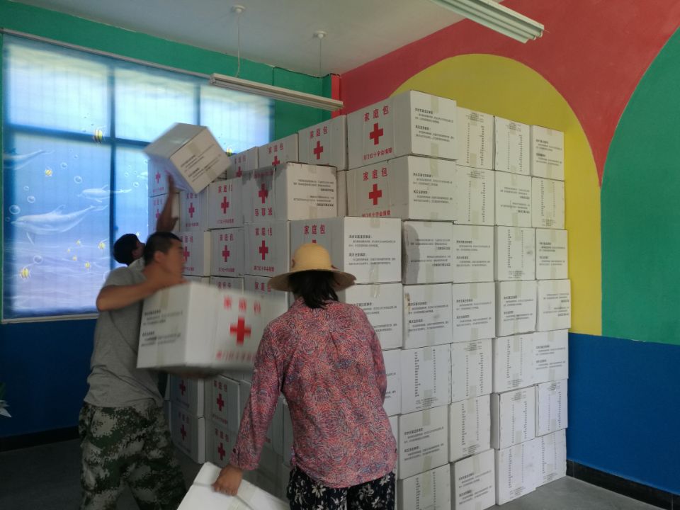 8月13日，澳门红十字会援助的300个家庭包运抵陇南市文县天池村，志愿者装卸家庭箱1.jpg